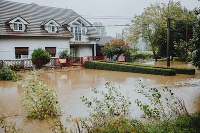 House with a yard under brown floodwater
